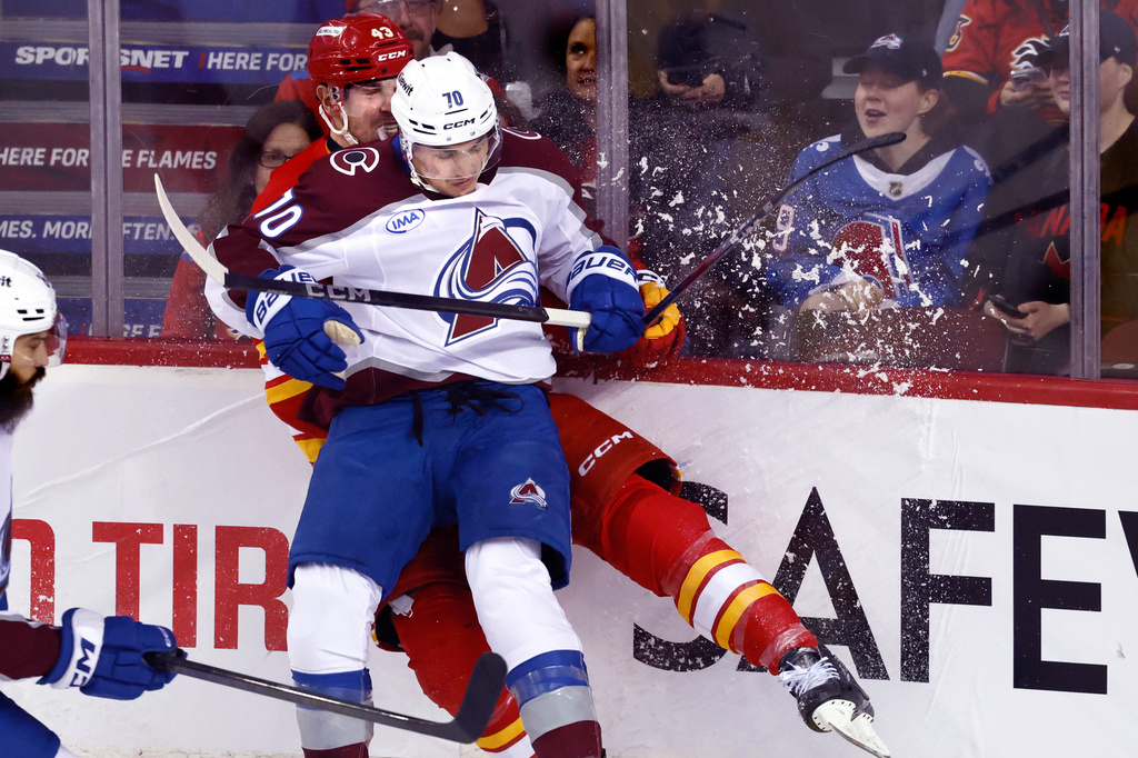 Colorado Avalanche's Sam Malinski, front, is hit by Calgary Flames' Adam Klapka during second period NHL hockey action in Calgary, Tuesday, April 14, 2026. THE CANADIAN PRESS/Larry MacDougal/The Canadian Press via AP)