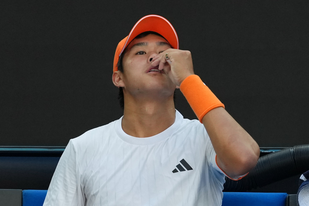 Learner Tien of the U.S. attempts to stop a nose bleed during his fourth round match against Daniil Medvedev of Russia at the Australian Open tennis championship in Melbourne, Australia, Sunday, Jan. 25, 2026. (AP Photo/Asanka Brendon Ratnayake)