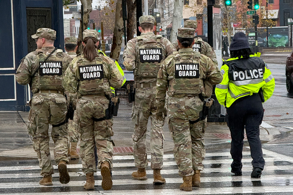 Members of the National Guard and an officer from the Washington Metropolitan Police Department on foot patrols in the U Street neighborhood of Washington, Sunday, Nov., 30, 2025. (AP Photo/Pablo Martinez Monsivais)