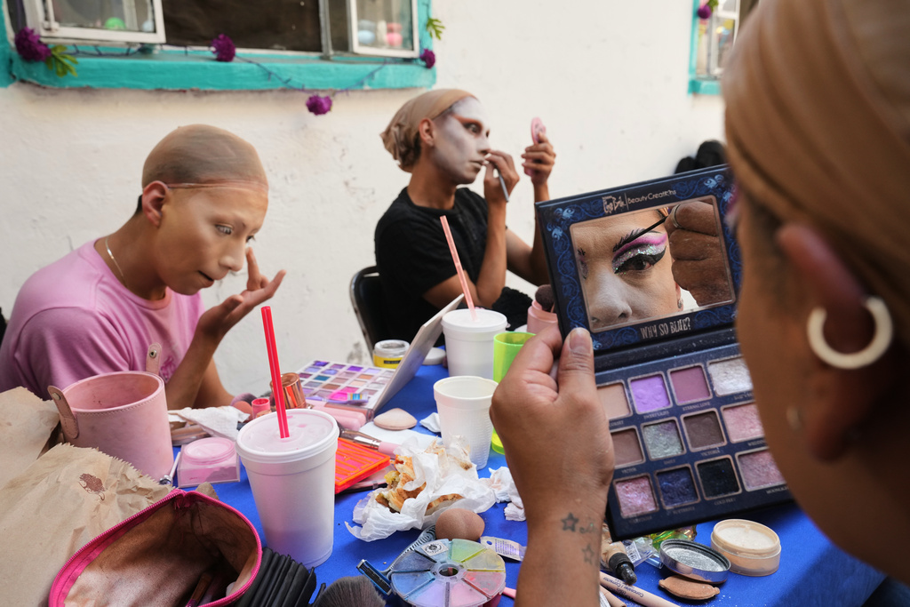 Drag artist Angel Arumir, right, applies makeup ahead of the Day of the Dead Catrina parade in Mexico City, Sunday, Oct. 26, 2025. (AP Photo/Claudia Rosel)