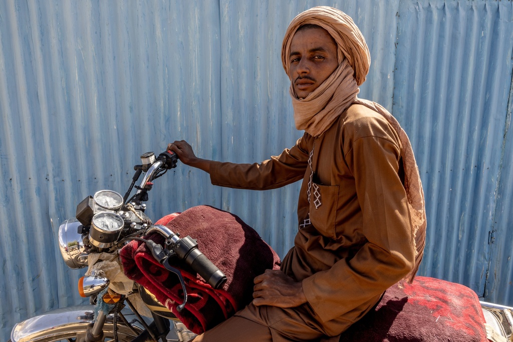 A man, whose shop was destroyed when Africa Corps burned his village in the Mopti region of Mali, poses on his motorcycle in Douankara, Hodh El Chargui Region, Mauritania, Nov. 7, 2025. (AP Photo/Caitlin Kelly)