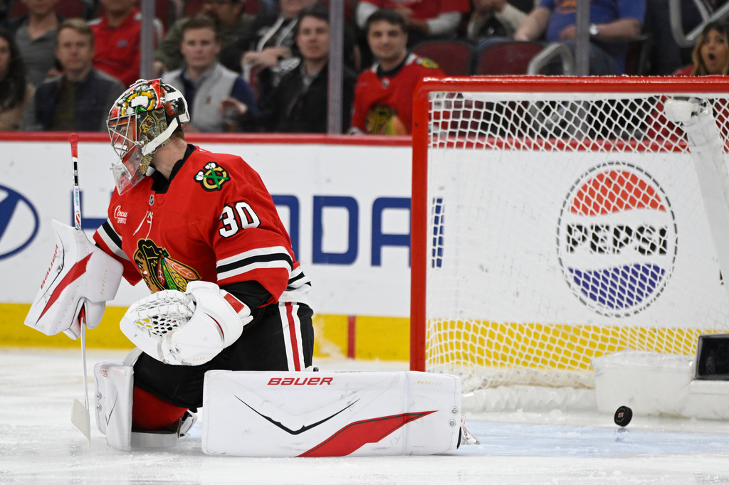 Chicago Blackhawks goalie Spencer Knight (30) misses a goal by Carolina Hurricanes' Sean Walker during the first period of an NHL hockey game in Chicago, Thursday, April 9, 2026. (AP Photo/Paul Beaty)
