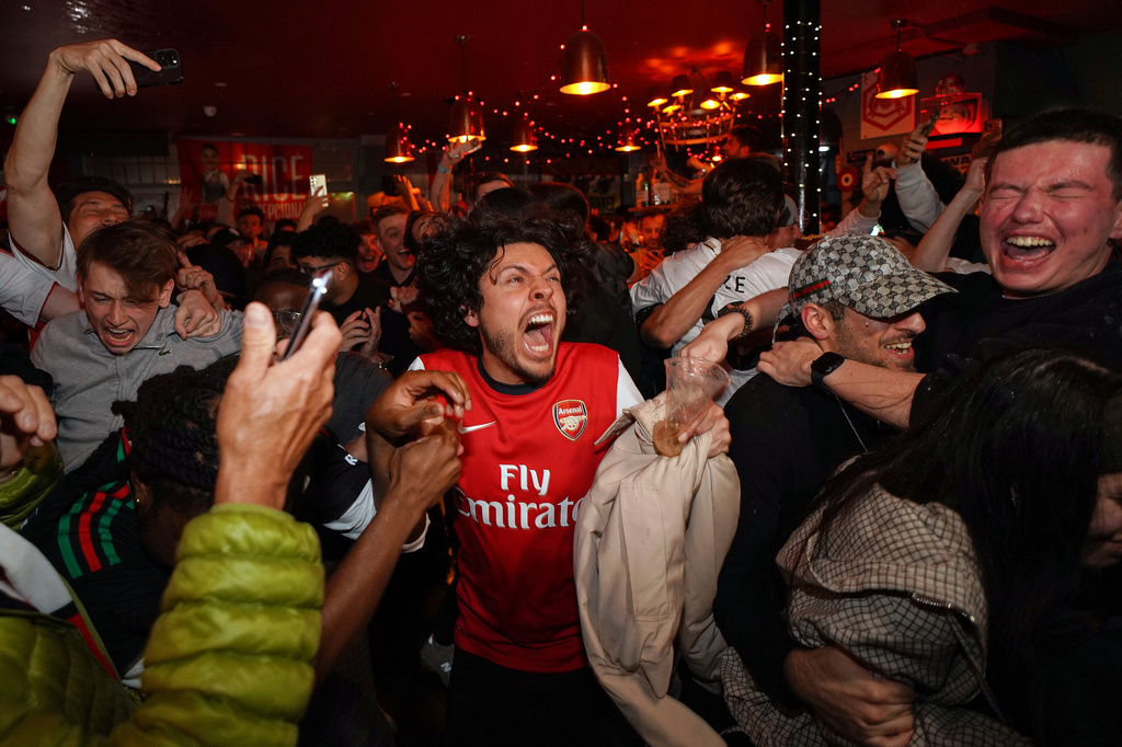 Arsenal supporters celebrate in a pub near the Arsenal stadium after Arsenal's soccer team won the Premier League title in London, Tuesday, May 19, 2026.(AP Photo/Alberto Pezzali)