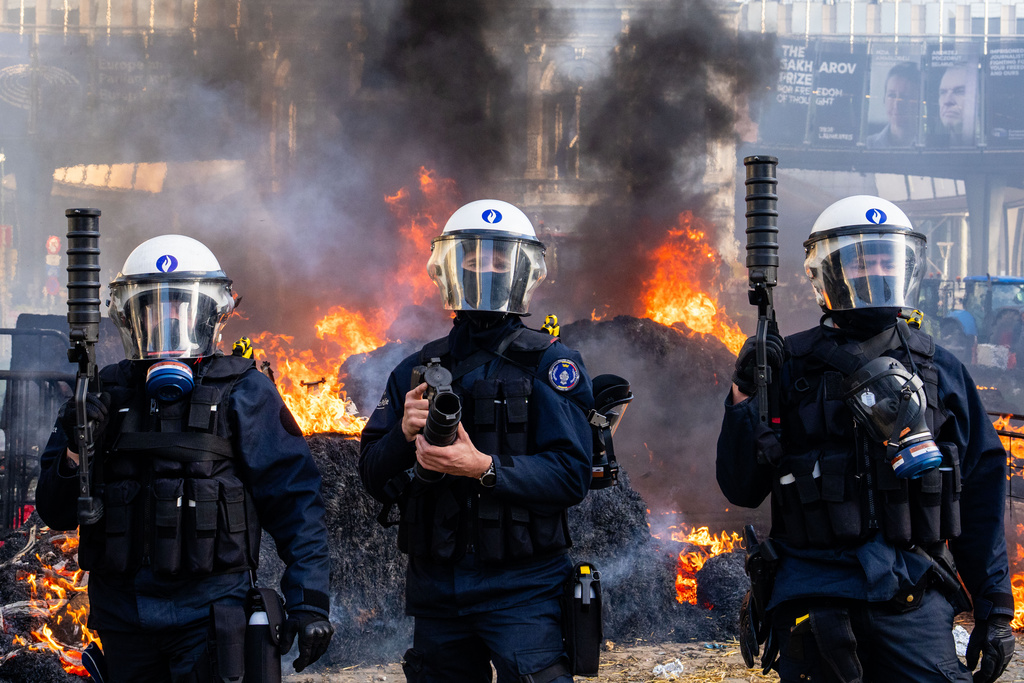 Police try to disperse protestors during a demonstration of European farmers near the European Parliament in Brussels, Thursday, Dec. 18, 2025. (AP Photo/Marius Burgelman)