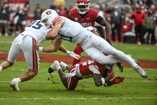Auburn quarterback Jackson Arnold (11) is tackled by Arkansas defensive back Caleb Wooden (22) during the first half of an NCAA college football game Saturday, Oct. 25, 2025, in Fayetteville, Ark. (AP Photo/Michael Woods) Auburn quarterback Jackson Arnold (11) is tackled by Arkansas defensive back Caleb Wooden (22) during the first half of an NCAA college football game Saturday, Oct. 25, 2025, in Fayetteville, Ark. (AP Photo/Michael Woods)