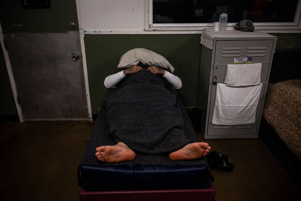 An inmate rests at the Pine Grove Youth Conservation Camp, July 14, 2025, in Red Corral, Calif. (AP Photo/Ethan Swope)