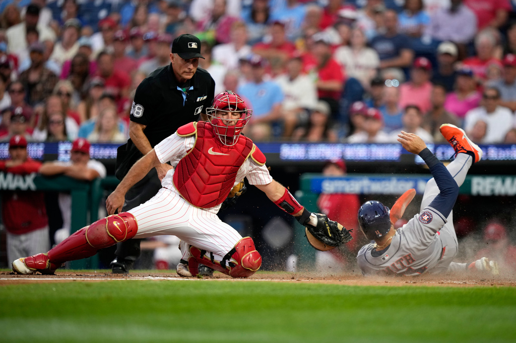 Houston Astros' Cam Smith, right, scores past Philadelphia Phillies catcher J.T. Realmuto on a double by Jeremy Peña during the second inning of a baseball game Tuesday, Sept. 8, 2026, in Philadelphia. (AP Photo/Matt Slocum)