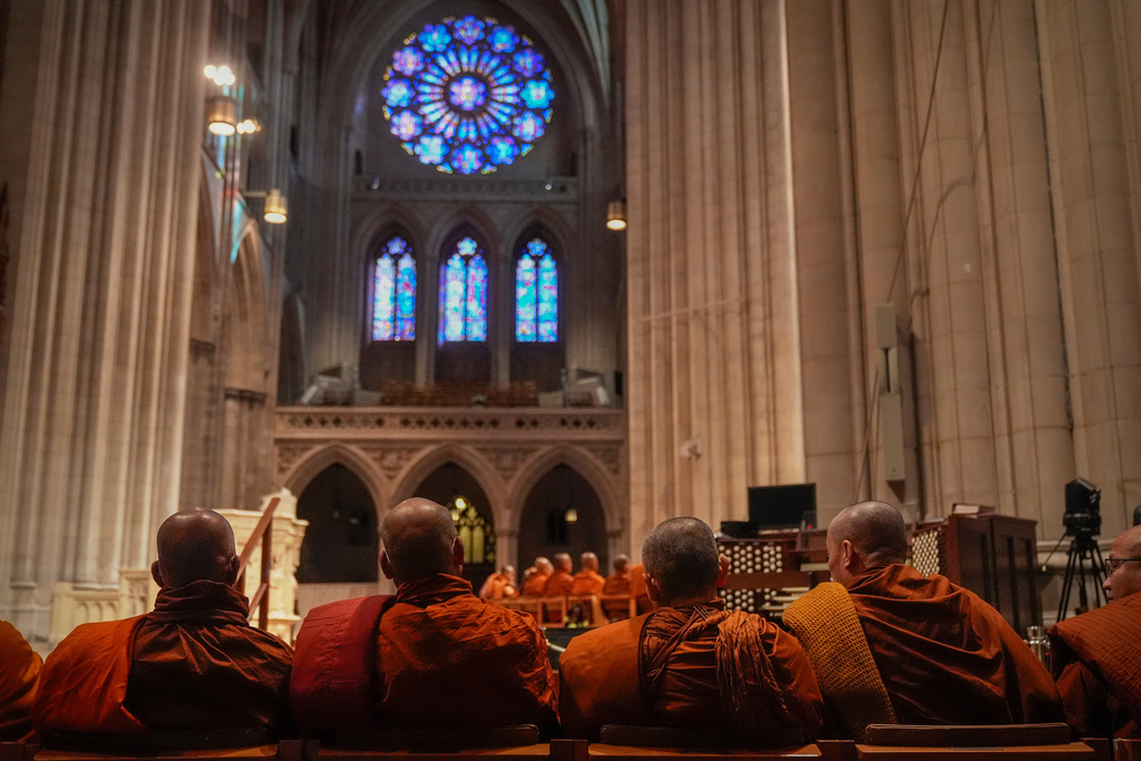 Buddhist monks sit in Washington National Cathedral during an event with monks who are participating in a Walk For Peace, Tuesday, Feb. 10, 2026, in Washington. (AP Photo/Mark Schiefelbein)
