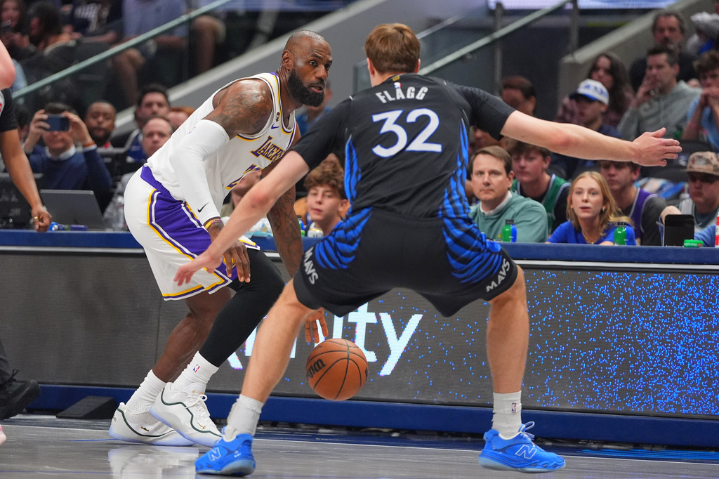 Los Angeles Lakers forward LeBron James (23) dribbles against Dallas Mavericks forward Cooper Flagg (32) during the first half of an NBA basketball game in Dallas, Sunday, April 5, 2026. (AP Photo/LM Otero)