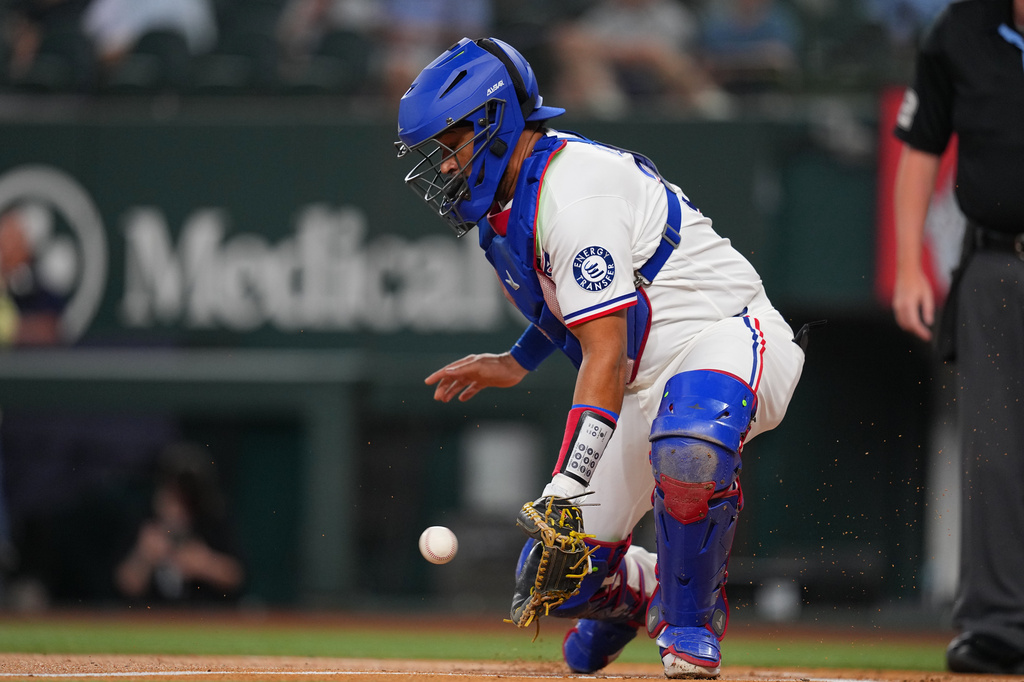 Texas Rangers catcher Elias DÌaz fields a throw from the outfield on a scoring double by Los Angeles Angels' Jorge Soler during the first inning of a baseball game, Tuesday, July 7, 2026, in Arlington, Texas. (AP Photo/Julio Cortez)