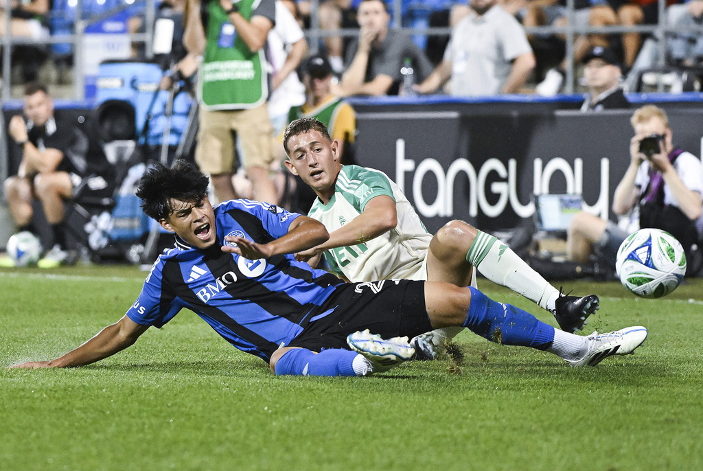 Austin FC's Nico Dubersarsky, right, slides in on CF Montreal's Olger Escobar (29) during the second half of an MLS soccer game in Montreal, Saturday, Aug. 23, 2025. (Graham Hughes/The Canadian Press via AP)