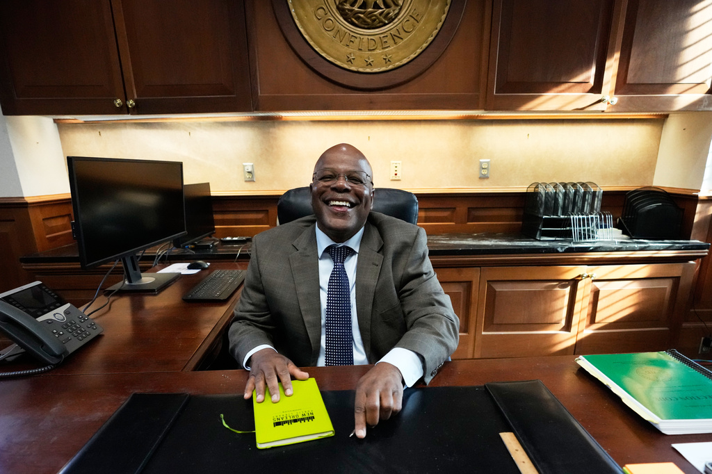 Calvin Duncan, left, an exoneree who was elected Orleans Parish clerk of criminal court, gets behind his desk on the first day of his term, Monday, May 4, 2026, in New Orleans. (AP Photo/Gerald Herbert)