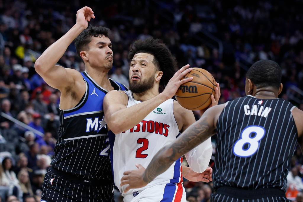 Detroit Pistons guard Cade Cunningham (2) goes to the basket between Orlando Magic forward Tristan da Silva (23) and forward Jamal Cain (8) during the first half in Game 5 of a first-round NBA basketball playoffs series Wednesday, April 29, 2026, in Detroit. (AP Photo/Duane Burleson)