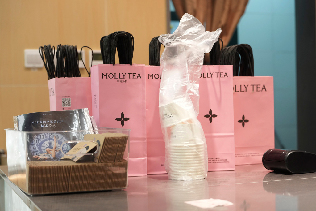 Bags with the Molly Tea brand and logo are seen at a shop in Beijing, China, Tuesday, July 7, 2026. (AP Photo/Ng Han Guan)