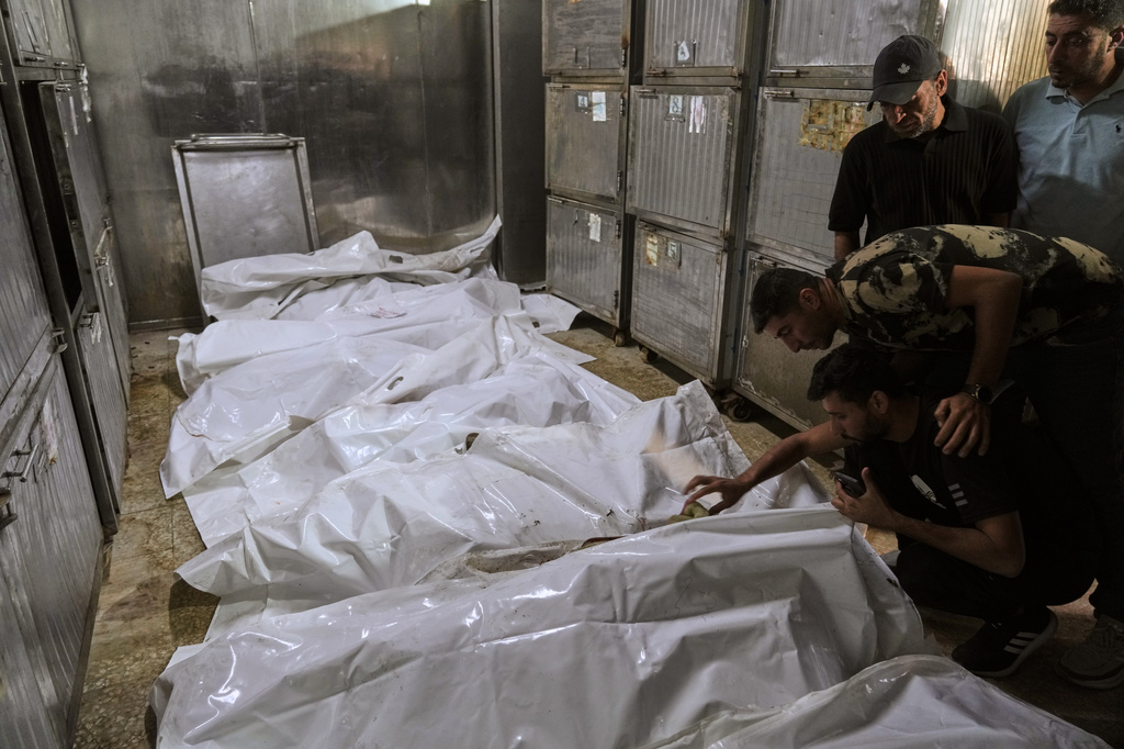 Palestinians mourn over the bodies of people killed in an Israeli strike, before their funeral in the morgue of Shifa Hospital in Gaza City, Thursday, June 4, 2026. (AP Photo/Jehad Alshrafi)