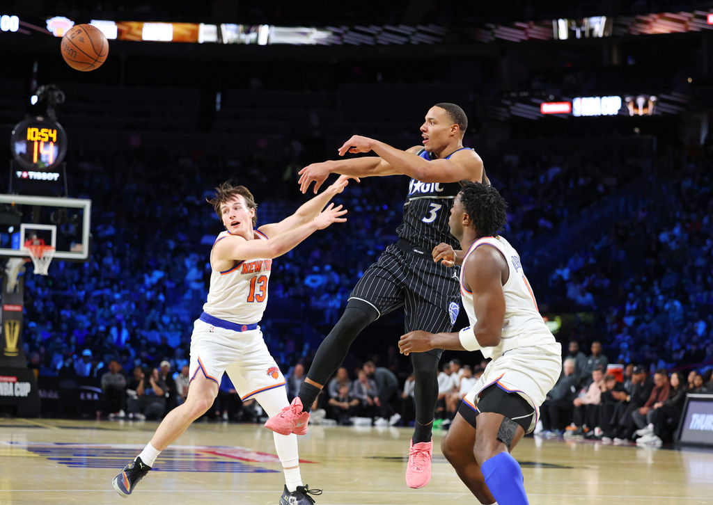 Orlando Magic guard Desmond Bane (3) passes the ball between New York Knicks' Tyler Kolek (13) and Og Anunoby (8) in the second half of an NBA Cup semifinals basketball game, Saturday, Dec. 13, 2025, in Las Vegas. (AP Photo/Ronda Churchill)
