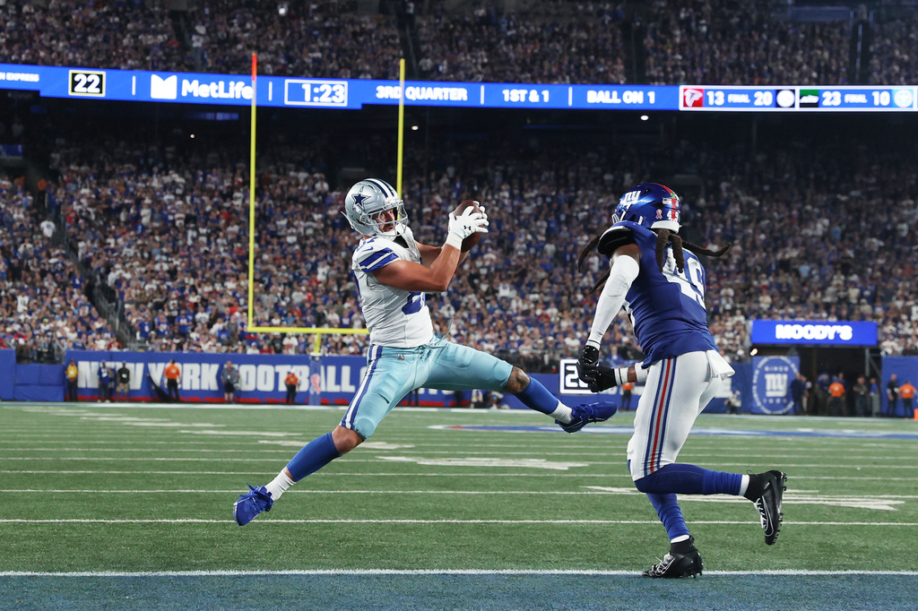 Dallas Cowboys tight end Jake Ferguson, left, makes a catch in front of New York Giants middle linebacker Tremaine Edmunds during the second half of an NFL football game Sunday, Sept. 13, 2026, in East Rutherford, N.J. (AP Photo/Pamela Smith)
