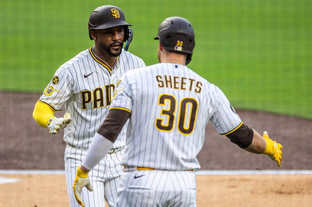 San Diego Padres' Miguel Andujar, left, celebrates his home run hit in the first inning with Gavin Sheets (30) in a baseball game against the Los Angeles Dodgers, Monday, May 18, 2026, in San Diego. (AP Photo/Tony Ding)