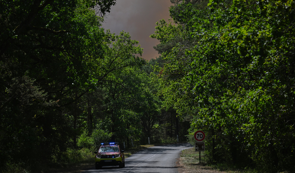 A fire command vehicle makes its way through a wildfire in the Fontainebleau forest region, south of Paris, France, Monday, July 13, 2026. (AP Photo/Emma Da Silva)