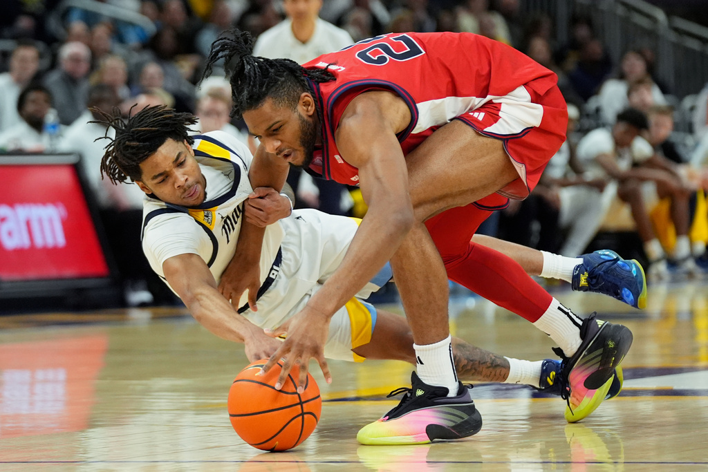 Marquette's Nigel James Jr., left, and Zuby Ejiofor, right, go after a loose ball during the first half of an NCAA college basketball game Wednesday, Feb. 18, 2026, in Milwaukee. (AP Photo/Aaron Gash)