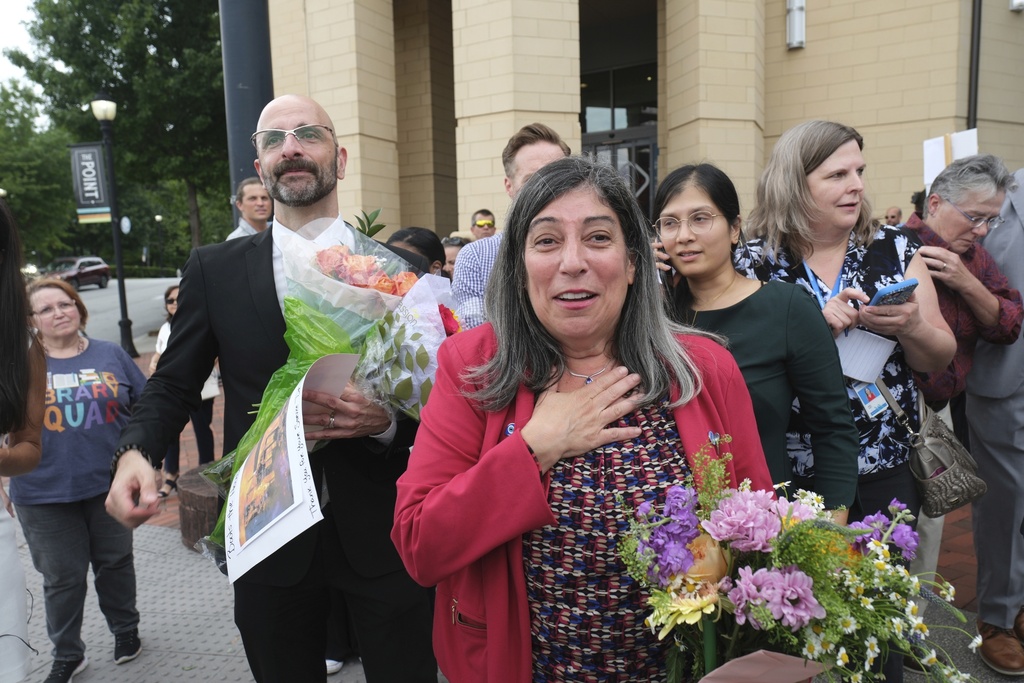 Dr. Demetre Daskalakis, left, and Dr. Debra Houry is greeted by friends as workers and supporters rally for departing scientific leaders at the Centers for Disease Control and Prevention outside the CDC headquarters, Thursday, Aug. 28, 2025, in Atlanta. (AP Photo/Ben Gray)