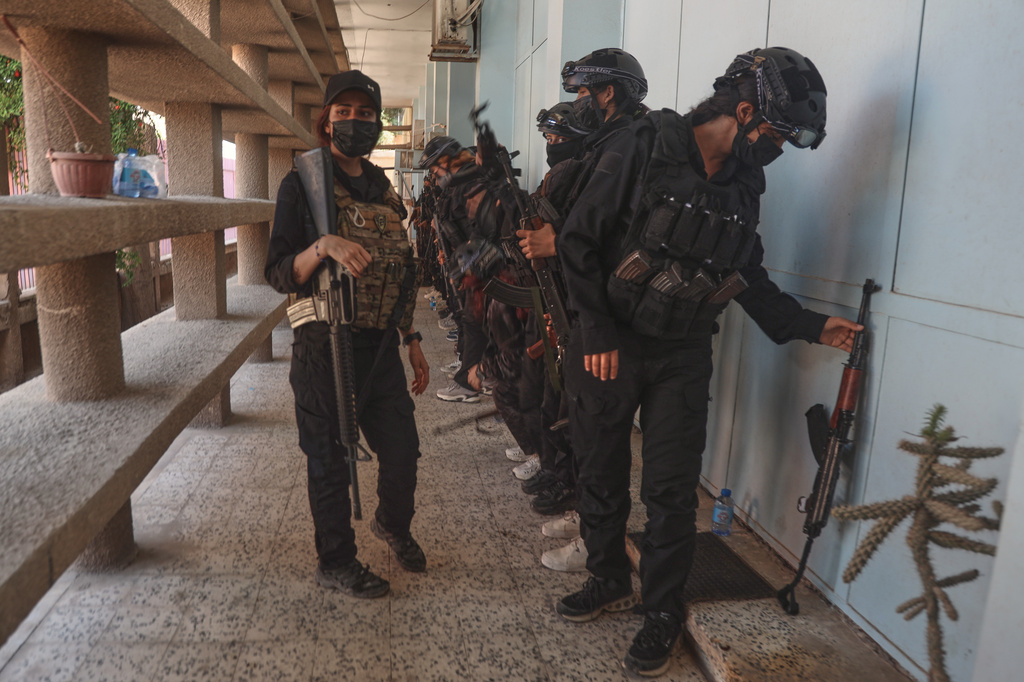 Security forces stand guard outside a polling station during follow-up parliamentary elections in Hassakeh, northeastern Syria, Sunday, May 24, 2026. (AP Photo/Baderkhan Ahmad)