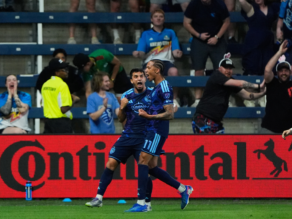 Sporting Kansas City forward Magomed Suleymanov, left, celebrates with forward Calvin Harris (11) after scoring a goal during the first half of an MLS soccer match against the Colorado Rapids, Saturday, March 21, 2026, in Kansas City, Kan. (AP Photo/Charlie Riedel)