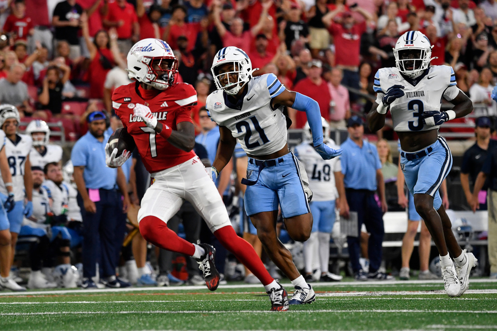 Louisville wide receiver Lawayne McCoy (7) looks back at the pursuit of Villanova defensive back Jayvont Williams (21) and Villanova defensive back Josh Oluremi (3) during the xx half of an NCAA college football game in Louisville, Ky., Friday, Sept. 11, 2026. (AP Photo/Timothy D. Easley)