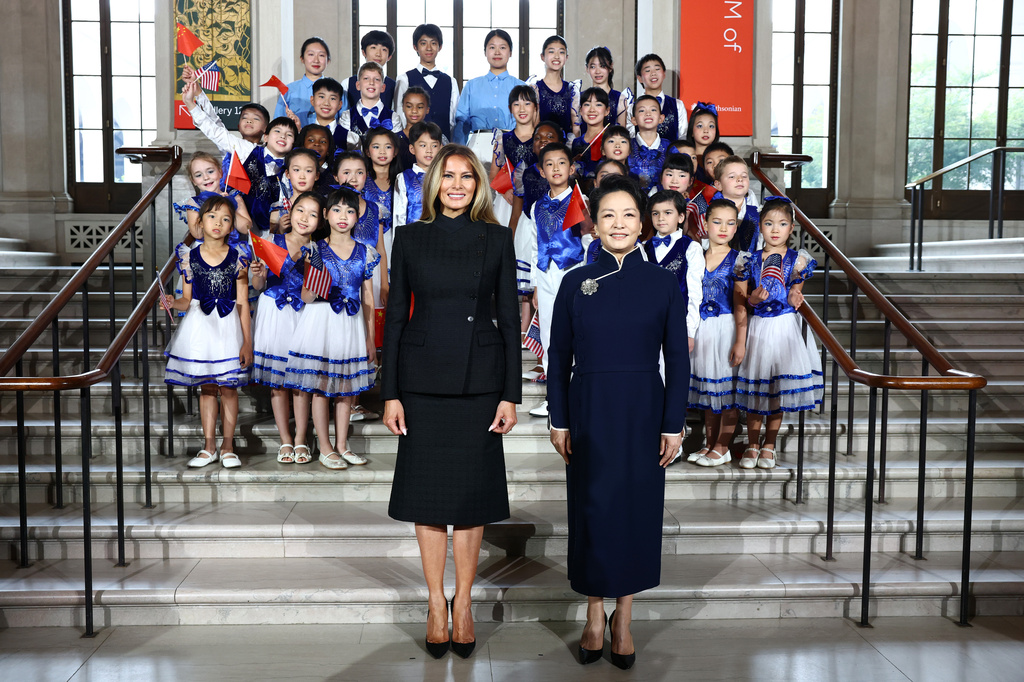 First lady of China Peng Liyuan, right, and first lady Melania Trump, pose for a photo with choir students from the Hope Chinese School at the Smithsonian's National Museum Of Asian Art, Thursday, Sept. 24, 2026, in Washington. (Finn Gomez/Pool Photo via AP)
