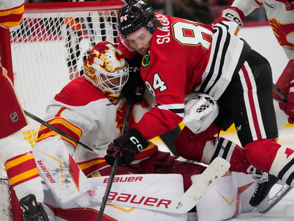 Chicago Blackhawks left wing Landon Slaggert, right, collides with Calgary Flames goaltender Devin Cooley during the third period of an NHL hockey game, Thursday, Jan. 15, 2026, in Chicago. (AP Photo/Erin Hooley)