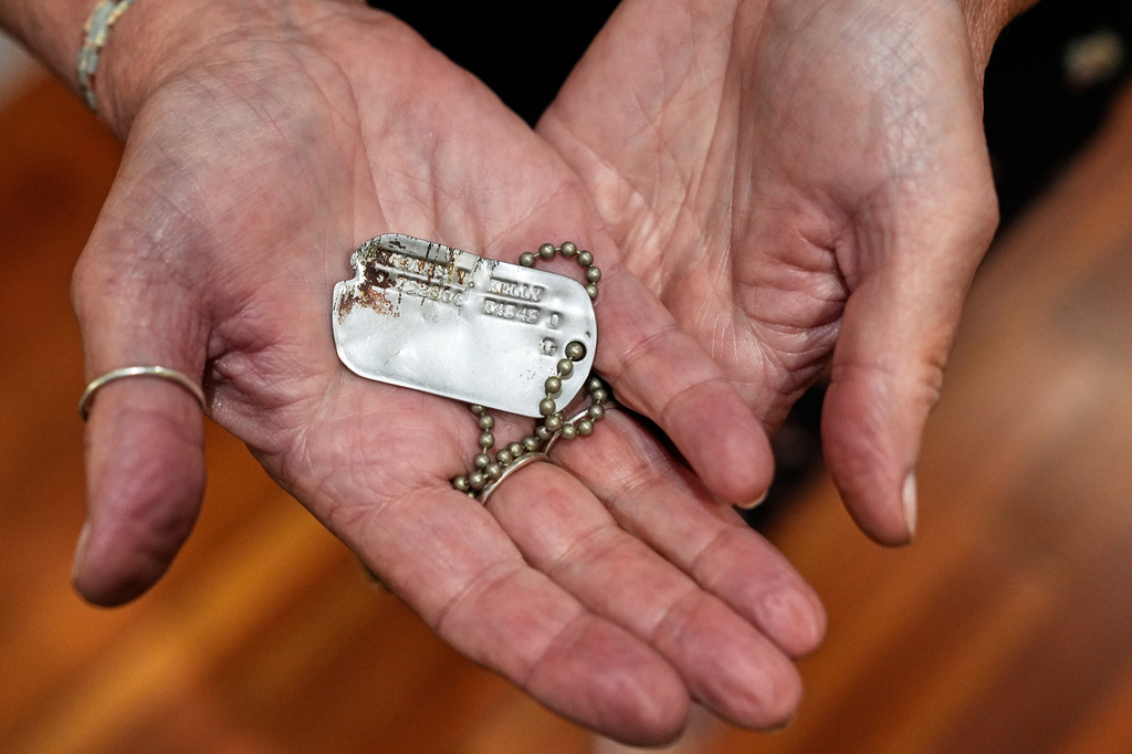 FILE- Diane Christie holds a recovered dog tag belonging to her uncle, World War II U.S. Army Air Forces 2nd Lt. Thomas Kelly, Friday, May 23, 2025, in San Leandro, Calif. (AP Photo/Godofredo A. Vásquez)