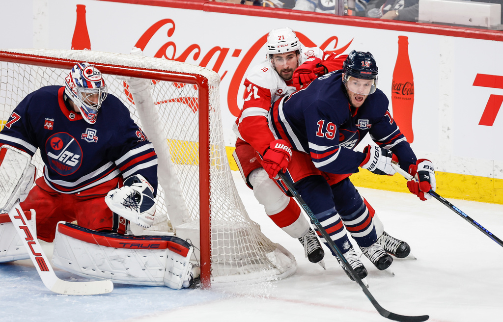 Winnipeg Jets' Jonathan Toews (19) defends against Detroit Red Wings' Dylan Larkin (71) during first-period NHL hockey game action in Winnipeg, Manitoba, Saturday, Jan. 24, 2026. (John Woods/The Canadian Press via AP)
