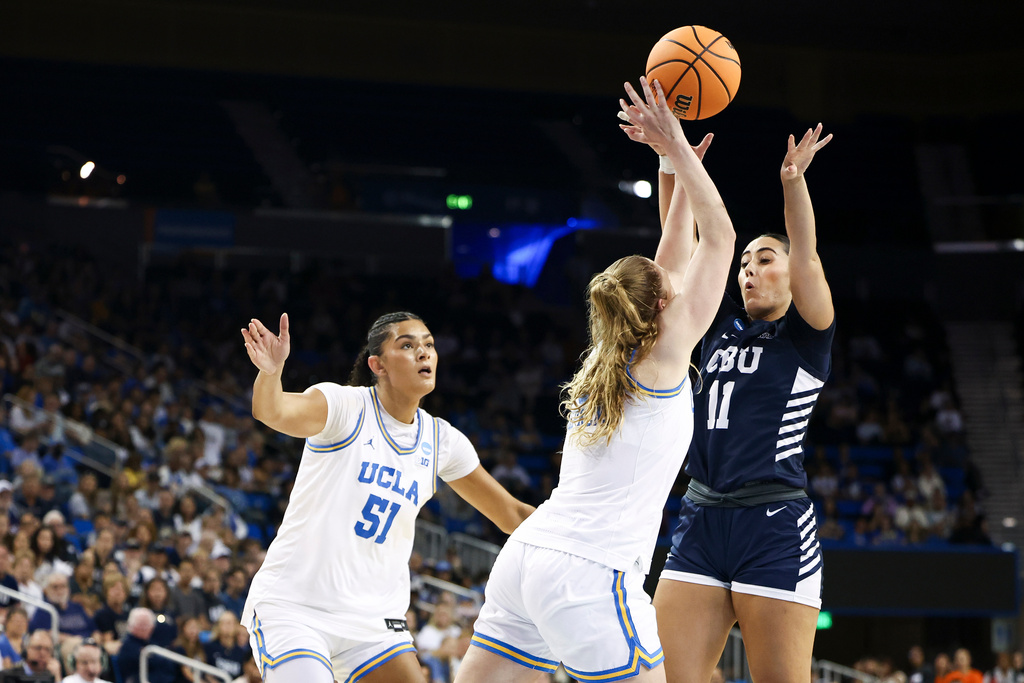 California Baptist guard Sofia Alonso (11) shoots against UCLA guard Gianna Kneepkens, center, as center Lauren Betts (51) watches during the first half in the first round of the NCAA college basketball tournament, Saturday, March 21, 2026, in Los Angeles. (AP Photo/Jessie Alcheh)