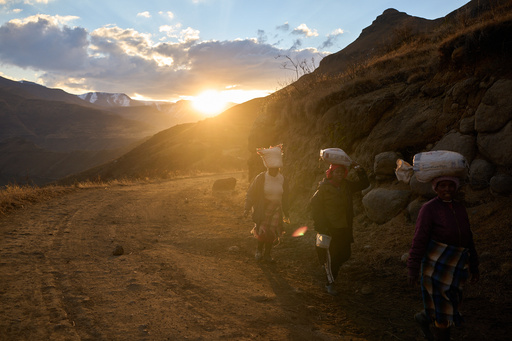 FILE - Women carry bags of food in the mountains of Ha Lejone, Lesotho, July 14, 2025. (AP Photo/Bram Janssen, File) FILE - Women carry bags of food in the mountains of Ha Lejone, Lesotho, July 14, 2025. (AP Photo/Bram Janssen, File)