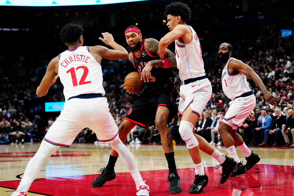 Toronto Raptors' Brandon Ingram, center, battles with Los Angeles Clippers' Cam Christie (12) and Kobe Sanders, second from right, during second-half NBA basketball game action in Toronto, Friday, Jan. 16, 2026. (Frank Gunn/The Canadian Press via AP)