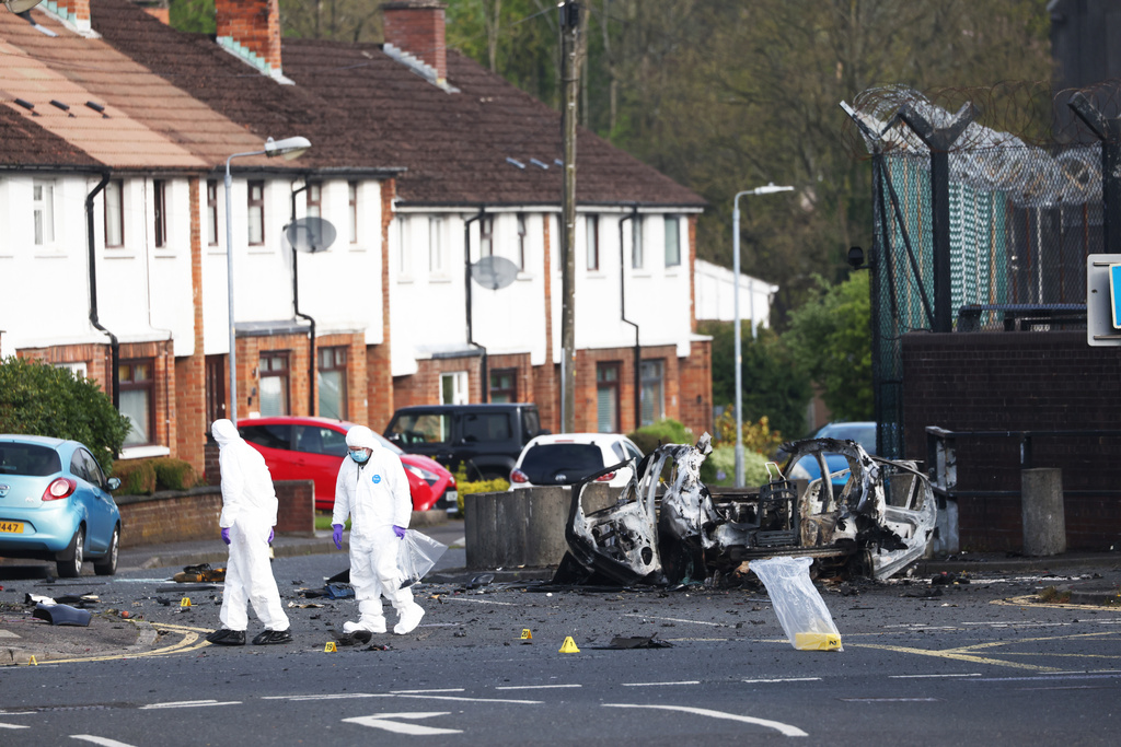 Forensic investigators inspect the site of a car bomb that exploded outside Dunmurry police station in South Belfast, Sunday, April 26, 2026. (AP Photo/Peter Morrison)