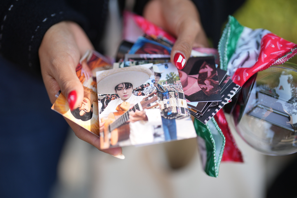 Aradith Gabriel from Mexico, a fan of K-pop band BTS, shows a photo of the BTS members, one of the goods and gifts she brought to exchange with fans from around the world ahead of the comeback concert of K-pop band BTS in Seoul, South Korea, Saturday, March 21, 2026. (AP Photo/Lee Jin-man)