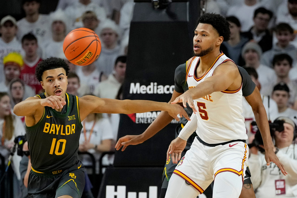 Iowa State forward Joshua Jefferson (5) passes around Baylor guard Isaac Williams (10) during the first half of an NCAA college basketball game, Saturday, Feb. 7, 2026, in Ames, Iowa. (AP Photo/Charlie Neibergall)