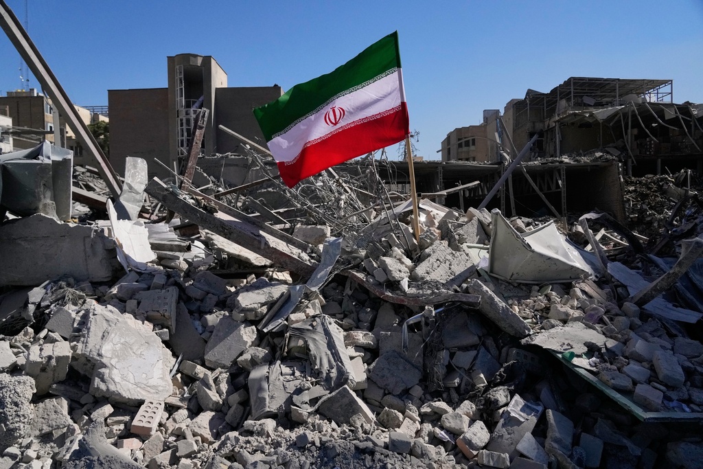 An Iranian flag is placed among the ruins of a police station struck Monday during the U.S.–Israeli military campaign in Tehran, Iran, Tuesday, March 3, 2026. (AP Photo/Vahid Salemi)