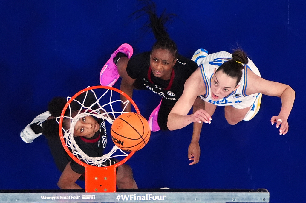 FILE - UCLA forward Angela Dugalic, right, shoots over South Carolina guard Ta'Niya Latson, center, and South Carolina forward Joyce Edwards during the first half of the women's National Championship Final Four NCAA college basketball tournament game, April 5, 2026, in Phoenix. (AP Photo/Ross D. Franklin, File)