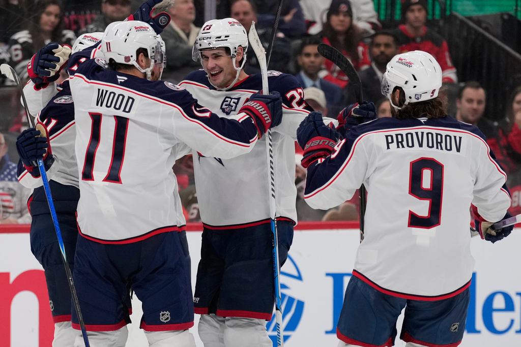 Columbus Blue Jackets' Sean Monahan, center, celebrates his goal with teammates during the third period of an NHL hockey game against the New Jersey Devils in Newark, N.J., Monday, Dec. 1, 2025. (AP Photo/Seth Wenig)