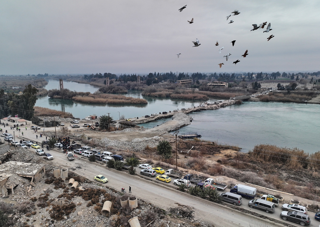 People cross a bridge over the Euphrates River in Deir Ezzor, eastern Syria, after Syrian government forces took control of the area following the withdrawal of Kurdish-led Syrian Democratic Forces (SDF), Thursday, Jan. 22, 2026. (AP Photo/Ghaith Alsayed)