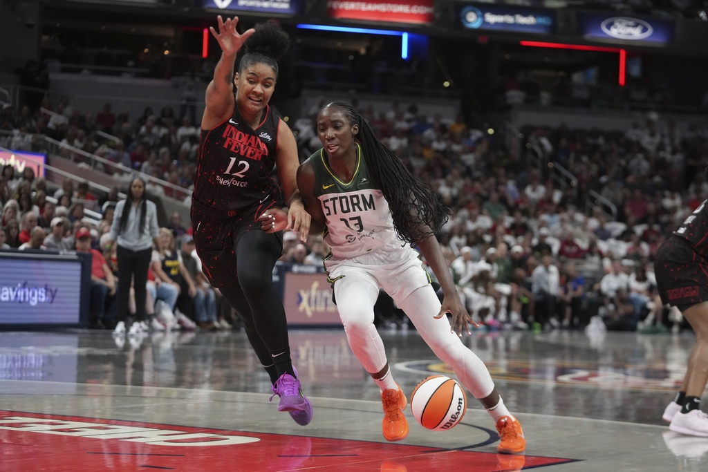 Seattle Storm forward Ezi Magbegor (13) goes to the basket against Indiana Fever forward Damiris Dantas (12) during the first half of a WNBA basketball game, Tuesday, Aug. 26, 2025, in Indianapolis. (AP Photo/Darron Cummings)