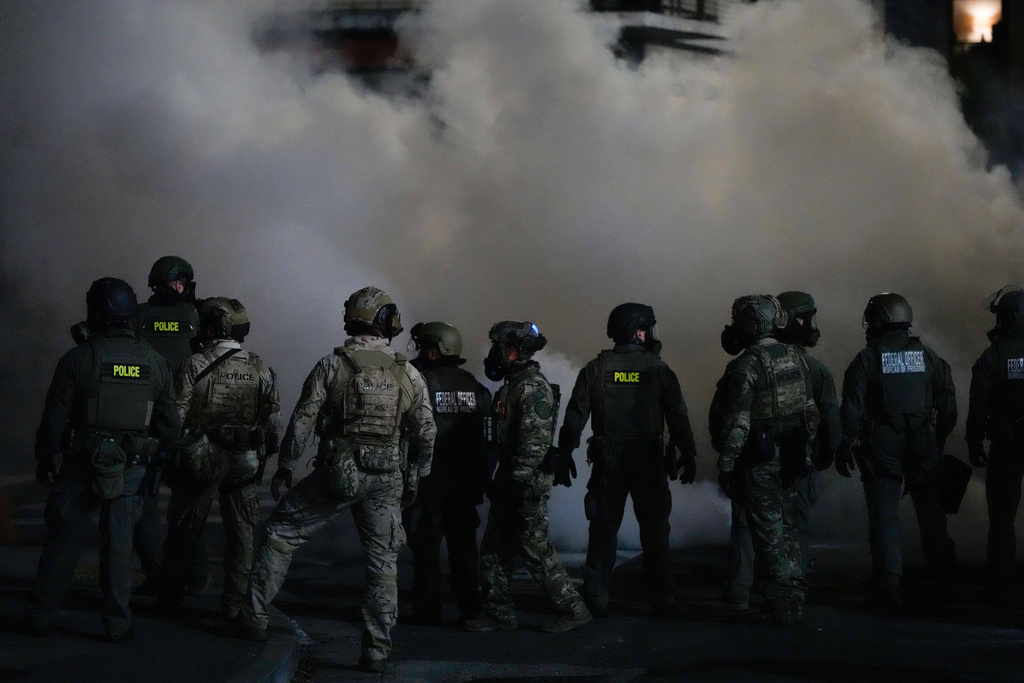 Federal officers stand after deploying tear gas outside a U.S. Immigration and Customs Enforcement facility during a protest on Saturday, Oct. 4, 2025, in Portland, Ore. (AP Photo/Jenny Kane)