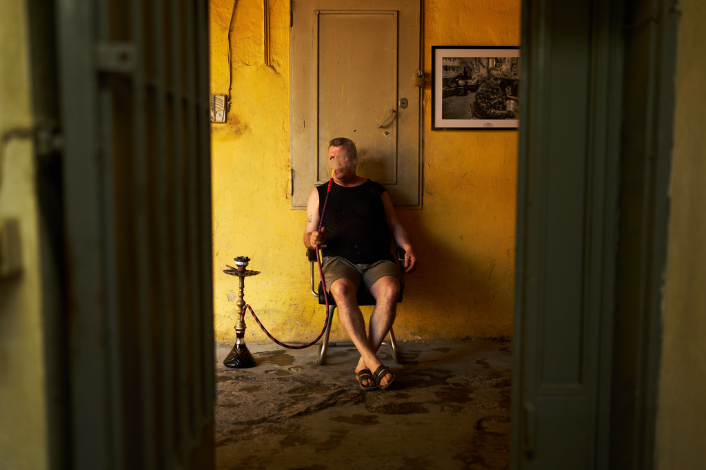 Master polisher Aydin Karaman smokes a water pipe during a break in his workshop in the Buyukhan artisan quarter in Istanbul, Turkey, Thursday, Aug. 6, 2026. (AP Photo/Francisco Seco)