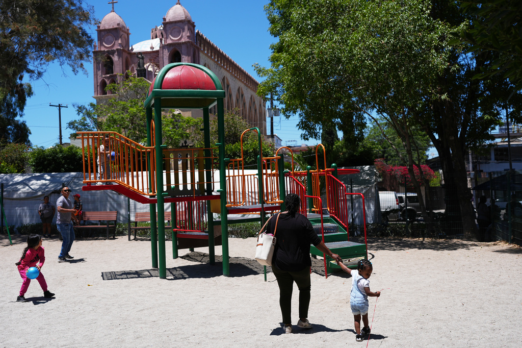 Vivianne Petit Frere walks with her granddaughter Alexca at a playground, June 22, 2026, in Tijuana, Mexico. (AP Photo/Gregory Bull)