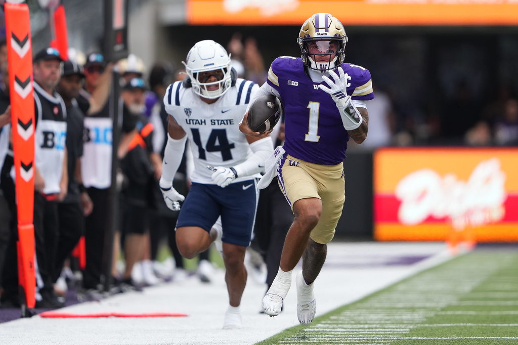 Washington quarterback Demond Williams Jr. runs the ball against Utah State linebacker Bronson Olevao Jr. (14) during the second half of an NCAA college football game Saturday, Sept. 12, 2026, in Seattle. (AP Photo/Lindsey Wasson)