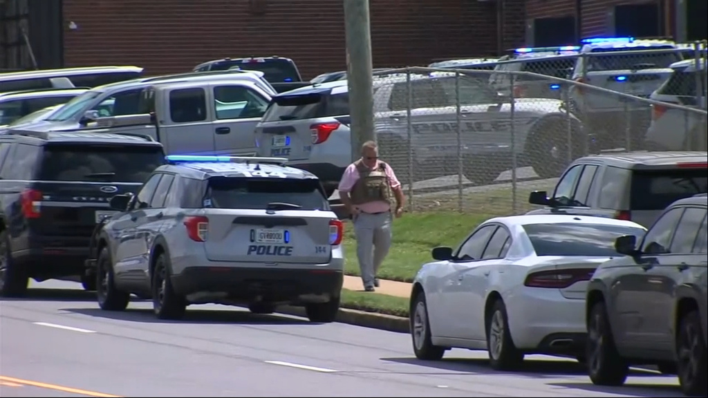 In this image from video provided by WGXA-TV, a police officer walks outside Warner Robins High School after a shooting in Warner Robins, Ga., on Wednesday, Aug. 12, 2026. (WGXA-TV via AP)