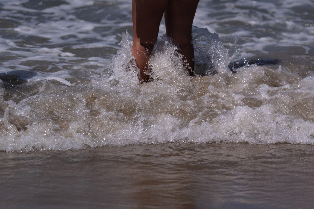 A beachgoer stands in shallow water at Bolsa Chica State Beach in Huntington Beach, Calif., Friday, July 24, 2026. (AP Photo/Jae C. Hong)