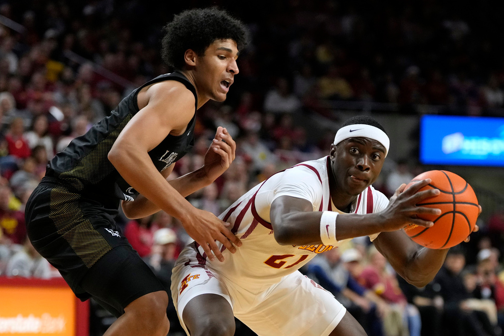 Iowa State guard Killyan Toure, right, passes around Long Beach State guard Gavin Sykes, leeft, during the second half of an NCAA college basketball game, Sunday, Dec. 21, 2025, in Ames, Iowa. (AP Photo/Charlie Neibergall)